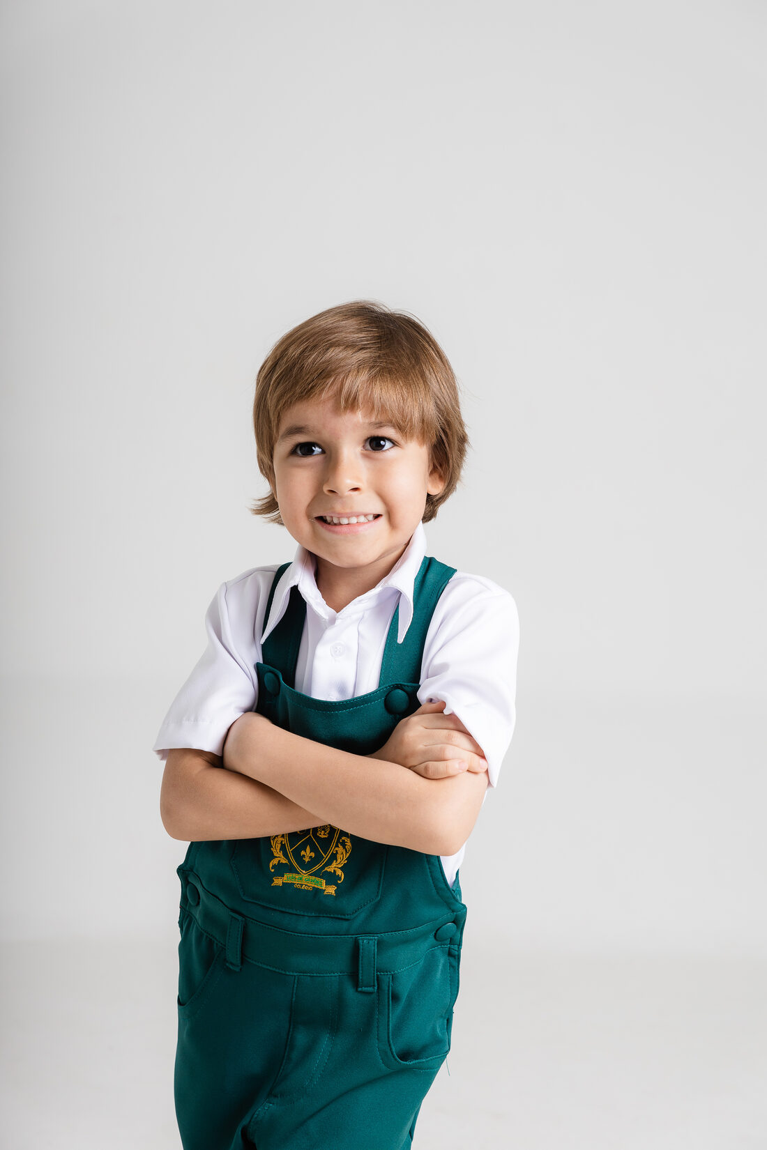 Aluno da Educação Infantil de braços cruzados, sorrindo