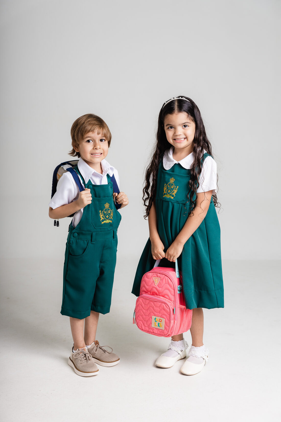 Dois alunos com mochilas, prontos para a escola