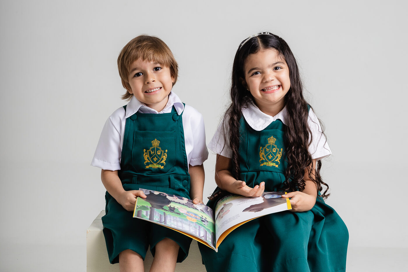 Alunos do Colégio Luís de Camões segurando um livro aberto